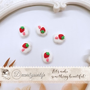 May include: Five white, strawberry-shaped decorative embellishments. Each has a red strawberry with a green stem and a pink accent. The image also includes the text "Decor&yourlife" and "Let's make something beautiful!"