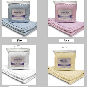 May include: Four baby blankets in different colors: blue, pink, white, and yellow. Each blanket is folded and packaged in a clear plastic bag with a handle. The label reads "Mink Touch Luxury Baby Blanket."