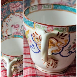Op de afbeelding: Een vintage theekopje en schotelset met een bloemenmotief in tinten roze, blauw en geel. Het kopje heeft een delicaat handvat en een brede rand.