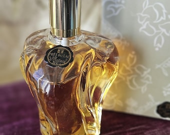 May include: A clear glass bottle of perfume with a gold spray nozzle and a black label that reads "Près du Lac Clairsel Paris".
