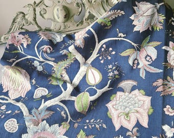 May include: A navy blue fabric with a large floral pattern. The design features large flowers in shades of pink, white, and green, along with detailed branches and leaves. The fabric is draped over a decorative, ornate headboard.