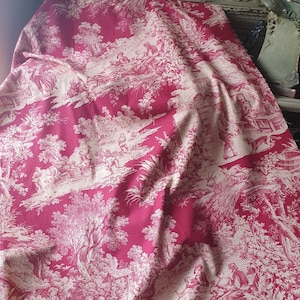 Puede incluir: Una tela drapeada con un diseño clásico de toile de Jouy en color rosa intenso con figuras blanquecinas. La escena pastoral representa figuras, árboles y edificios. Adecuada para la decoración del hogar o proyectos de artesanía.