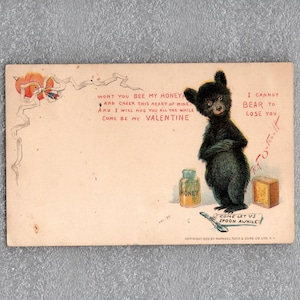 May include: Vintage Valentine's Day postcard featuring a black bear illustration. The bear stands near a honey jar and a small box. Text includes "Won't you bee my honey" and "I cannot bear to lose you."