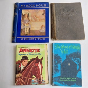May include: A collection of vintage children's books. Titles include "My Book House," "Jehovah's Praise," "Annette and the Mystery at Moonstone Bay," and "The Ghost of Windy Hill." The books feature colorful covers and illustrations, showcasing a variety of themes.