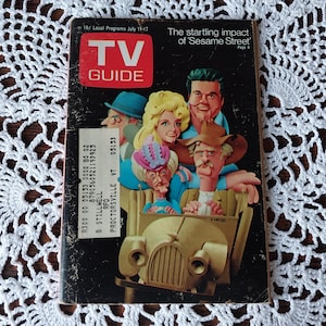 May include: Vintage TV Guide magazine cover featuring a colorful illustration of Sesame Street characters in a car. The magazine has the title "TV GUIDE" in a red box and the text "The startling impact of 'Sesame Street'".