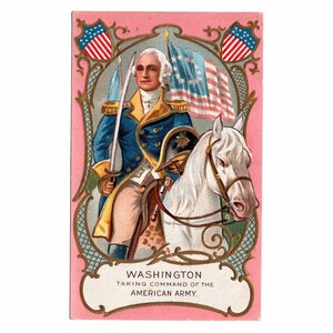 May include: A vintage rectangular trade card featuring a color illustration of George Washington on a white horse, wearing a blue military coat with gold trim, holding a sword. The text reads WASHINGTON TAKING COMMAND OF THE AMERICAN ARMY.
