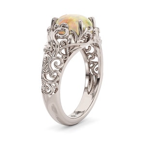 Könnte beinhalten: Ein silberner Ring mit einem filigranen Design und einem weißen Opal-Edelstein. Der Ring ist mit der Nummer 925 gekennzeichnet.