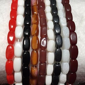 Puede incluir: Surtido de ocho hebras de cuentas de vidrio rectangulares. Las cuentas son de varios colores, incluidos rojo, blanco, negro, marrón y naranja.