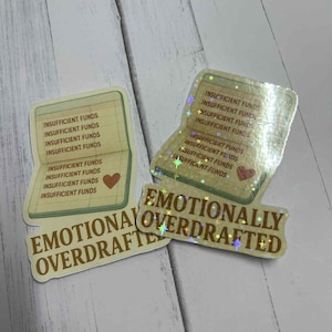 Könnte beinhalten: Drei Aufkleber mit Finanzthema. Zwei Aufkleber ähneln Scheckbüchern, mit den sich wiederholenden Worten "INSUFFICIENT FUNDS". Ein dritter Aufkleber lautet "EMOTIONALLY OVERDRAFTED" in braunen Buchstaben.