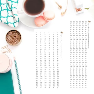 May include: A printable calendar sheet with numbers 1 through 30 listed down the left side and the days of the week listed across the top. The calendar sheet is on a white background with a cup of coffee, macarons, and gold paper clips.