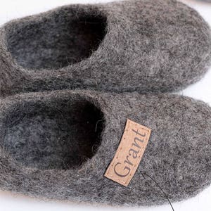 May include: A pair of grey wool slippers with a brown leather label that says "Grant". Any name can be attached here.