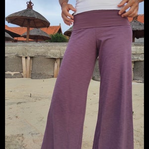May include: Purple wide-leg pants with a wide waistband. The pants are made of a soft, comfortable fabric and have a relaxed fit.