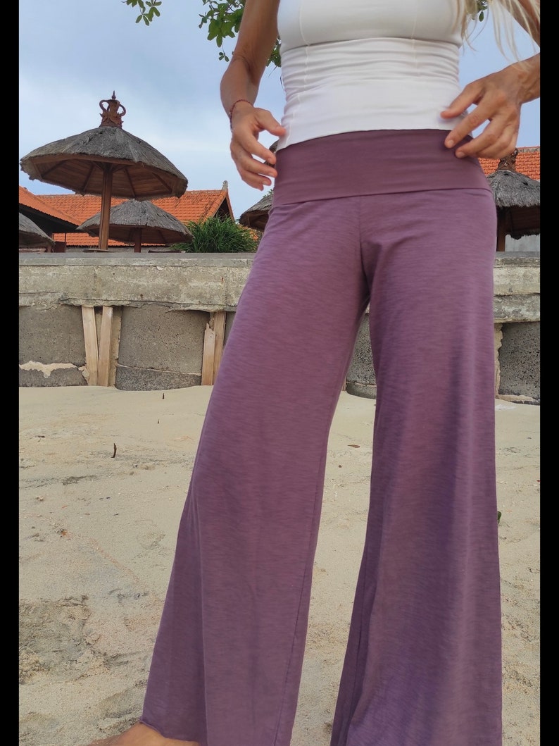 May include: Purple wide-leg pants with a wide waistband. The pants are made of a soft, comfortable fabric and have a relaxed fit.