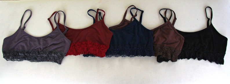 May include: Six different colored bras with lace trim. The bras are in shades of purple, red, blue, brown, and black.
