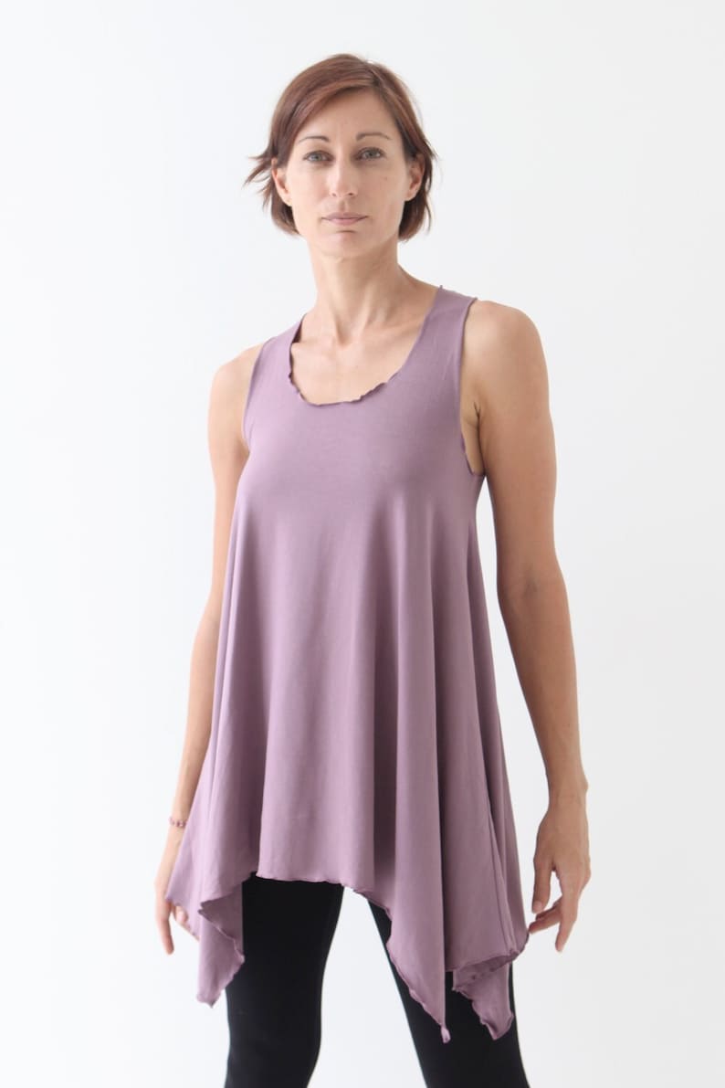 May include: A mauve sleeveless top with a slightly asymmetrical hemline. The top is made of a soft, comfortable fabric and has a relaxed fit.
