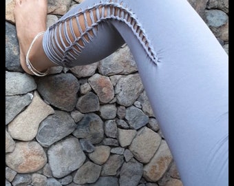 May include: Gray leggings with a unique design featuring a braided detail along the side of each leg.