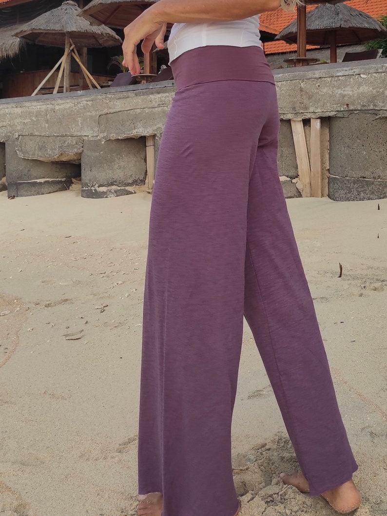 May include: A pair of wide-leg pants in a deep purple color. The pants have a wide waistband and a relaxed fit.