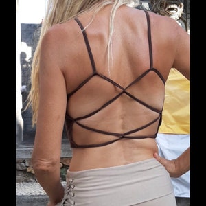Könnte beinhalten: Ein braunes Tanktop mit Kreuzrücken und einem beigefarbenen Rock mit Schnürung an der Seite.