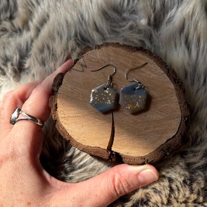Pendientes hexagonales de arcilla azul marino con detalles en escamas de oro, joyería de estilo bohemio espiritual.