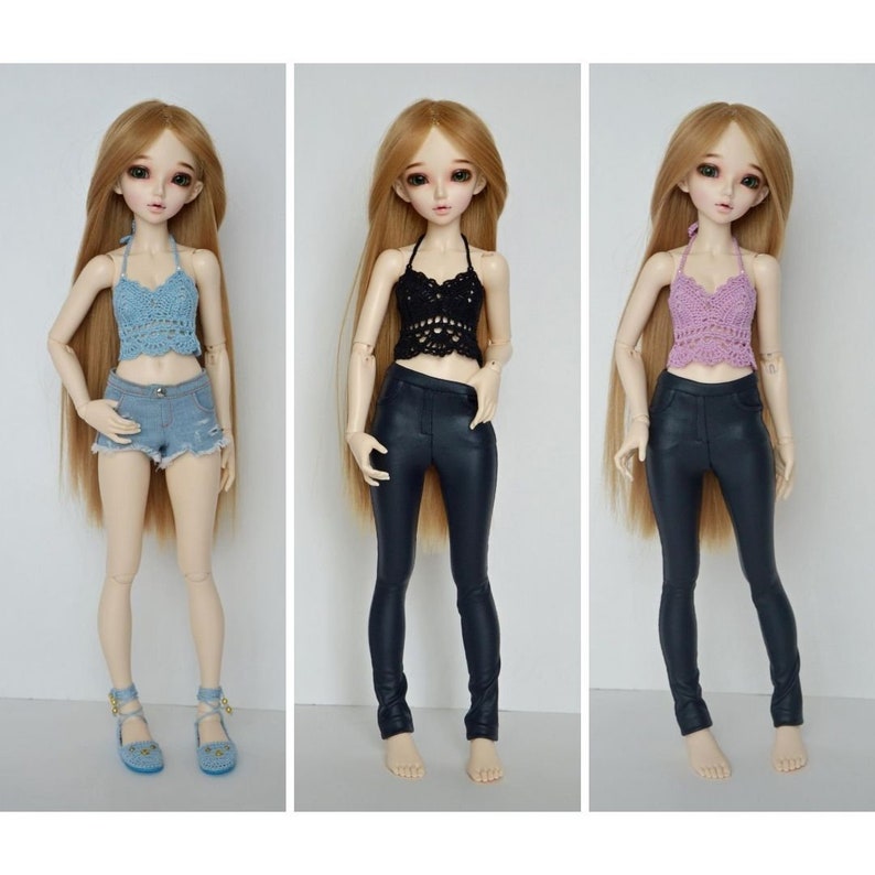 May include: Three dolls are displayed, each wearing a different outfit. The first doll is wearing a blue crochet halter top, denim shorts, and blue sandals. The second doll is wearing a black crochet halter top and black pants. The third doll is wearing a purple crochet halter top and black pants.