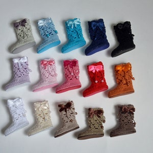 Puede incluir: Una colección de 14 botas de muñeca de ganchillo en varios colores y con adornos, incluyendo lazos y cuentas.