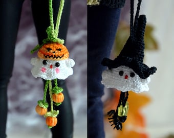 May include: Two handmade crochet ornaments featuring white ghost figures. The left ghost wears an orange pumpkin hat and hangs with three small orange pumpkins. The right ghost wears a black witch hat and hangs with a small black spider and yellow bead.
