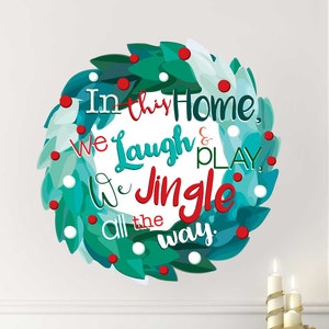 May include: A teal and green Christmas wreath with red berries and white dots. The wreath has the text "In this home, we laugh & we jingle all the way."