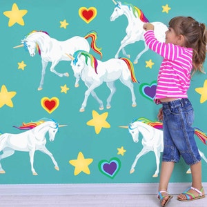 May include: A turquoise wall with rainbow unicorn wall decals. The decals feature white unicorns with rainbow manes and tails. There are also yellow stars and purple, green, and red hearts on the wall.
