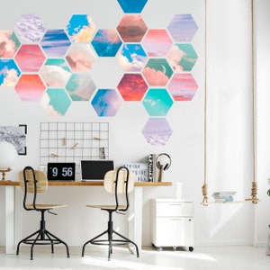 May include: A modern home office with a white desk, two black and wood chairs, and a wall decorated with hexagonal cloud art. A laptop, clock, and accessories are on the desk. A swing and a white cabinet are also in the room.