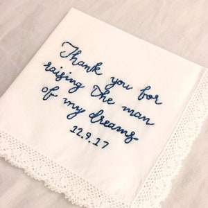 Image shows a white handkerchief with a detailed edge, folded into quarters. The text is the standard message for this listing, with a date added on, in blue thread.