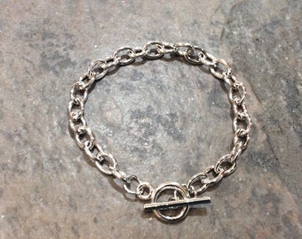 May include: A silver chain bracelet with a toggle clasp.