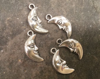 Puede incluir: Cinco dijes de plata en forma de media luna con una cara en cada uno. Los dijes tienen un agujero en la parte superior para sujetarlos a un collar o pulsera.