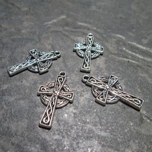 May include: Four silver Celtic cross charms with intricate knotwork designs. The charms are perfect for jewelry making or crafting.