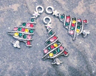 May include: Three silver-toned metal Christmas tree charms featuring a rope-textured design. Each charm is decorated with small, round, multi-colored rhinestones in shades of red, green, and yellow, and includes a small loop at the top for hanging.