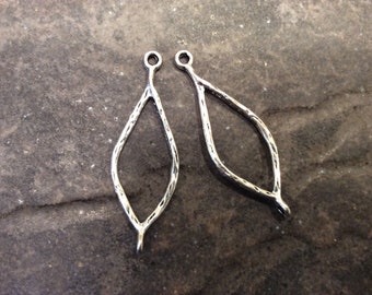 May include: Two silver-toned metal earring findings in the shape of a teardrop with a textured surface.