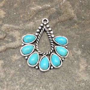 May include: Silver pendant with a teardrop shape and seven turquoise stones.