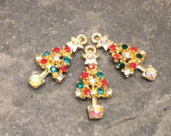 May include: Three gold-tone Christmas tree charms with red, green, and clear rhinestones.