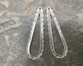 May include: Two elongated, teardrop-shaped silver metal jewelry components featuring a textured, scalloped edge with small raised dots and a twisted rope detail along the inner border, each topped with a small circular loop for attachment.