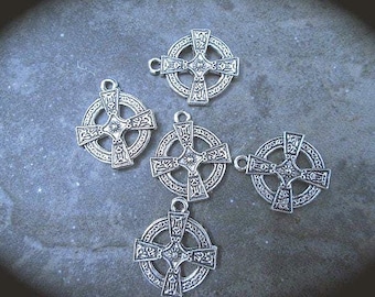 May include: Five silver-toned metal charms shaped like Celtic crosses, each featuring an intricate knotwork pattern within a circular frame and a small jump ring at the top for attachment. The charms have a weathered, oxidized finish.