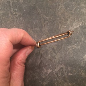 May include: A simple copper wire bracelet with a double-loop closure.