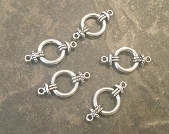May include: Five silver-toned metal clasps with a rope-like design. Each clasp has a circular ring and two loops for attaching to jewelry or other crafts.