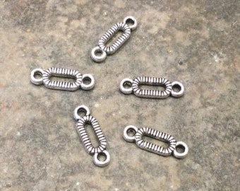 May include: Five silver-toned metal connector charms with a decorative oval design and two loops on each side.