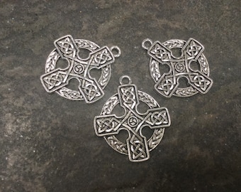 May include: Three silver Celtic cross charms with intricate knotwork designs. Each charm features a central circle with a smaller circle inside.