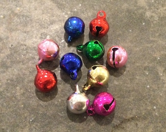 Può includere: Assortimento di piccole campanelle tintinnanti colorate. Le campanelle sono in metallo e hanno una finitura lucida. I colori includono rosso, rosa, blu, verde, oro e argento.
