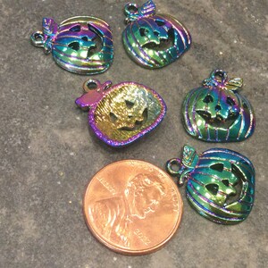 Pu&ograve; includere: Sei ciondoli a forma di zucca in metallo iridescente arcobaleno con facce di jack-o'-lantern. I ciondoli sono circa delle dimensioni di una moneta da un centesimo di euro.