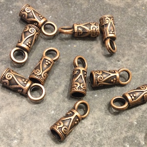 Terminales de cable ornamentados con lazo, acabado en cobre antiguo. Aptos para cables de hasta 4 mm. Paquete de 10 terminales con lazo.