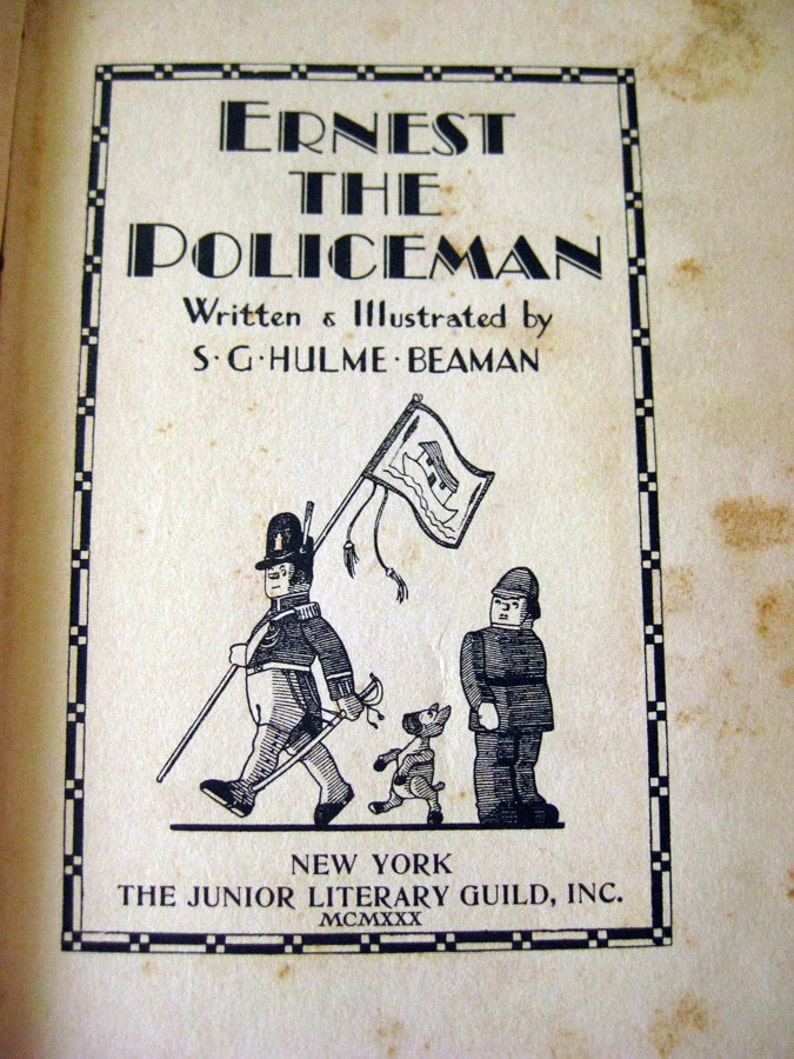 May include: Vintage book cover for "Ernest the Policeman" by S.G. Hulme Beaman. The cover features a black and white illustration of a policeman, a dog, and another figure. The title is in bold, stylized lettering, with the publisher's information at the bottom.