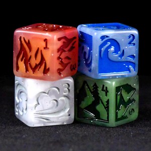 Puede incluir: Cuatro dados coloridos apilados. Los dados son rojos, azules, blancos y verdes. Cada dado presenta un s&iacute;mbolo elemental y un n&uacute;mero diferentes. El dado rojo tiene llamas y el n&uacute;mero 1. El dado azul tiene una ola y el n&uacute;mero 2.
