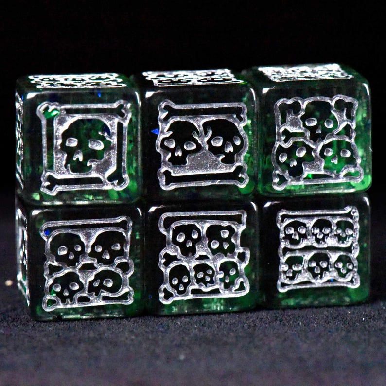 May include: Six green dice with silver skull and crossbones designs. Each die face features a different arrangement of skulls, creating a unique and thematic set. The dice are likely used for tabletop games.