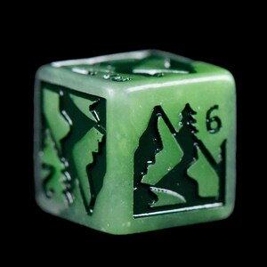 Puede incluir: Un dado verde transl&uacute;cido de seis caras con dise&ntilde;os de monta&ntilde;as y &aacute;rboles verde oscuro en cada cara. El n&uacute;mero 6 es visible en una cara. El dado est&aacute; sobre un fondo negro.